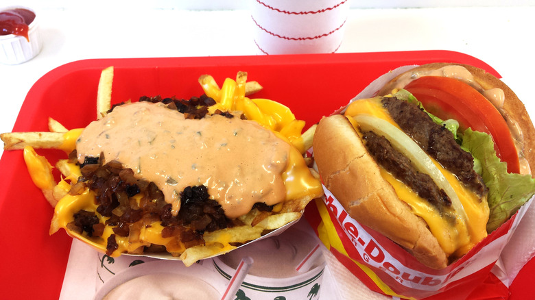 The Double-Double burger from In-N-Out next to the animal-style fries on a red tray.