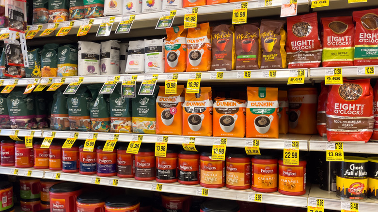 Coffee aisle in an American grocery store supermarket featuring various brands including, Folgers, Dunkin, Eight O Clock Coffee and Starbucks