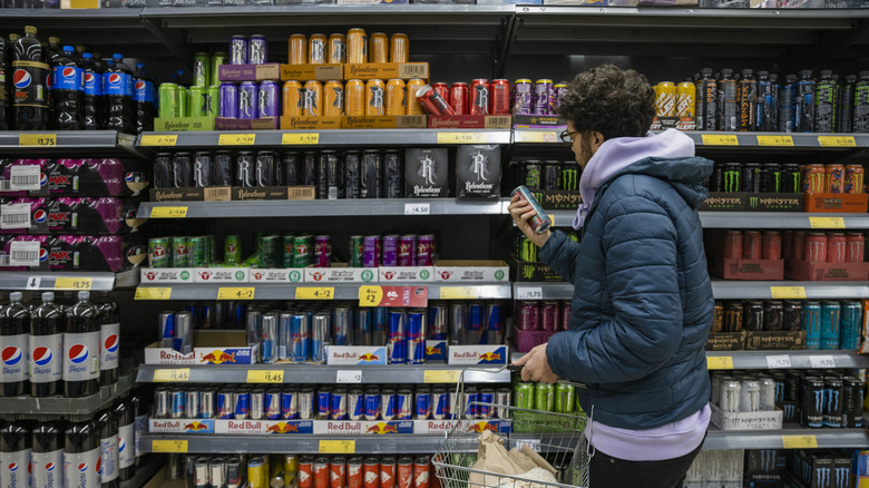 Man looking at energy drinks in aisle at super market