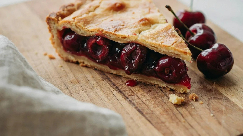 Slice of cherry pie on a wooden board
