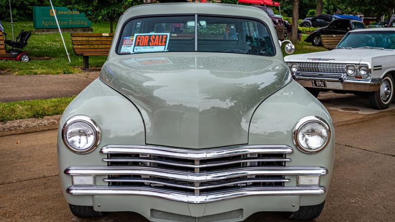 Old retro 1940s era car with a for sale sign