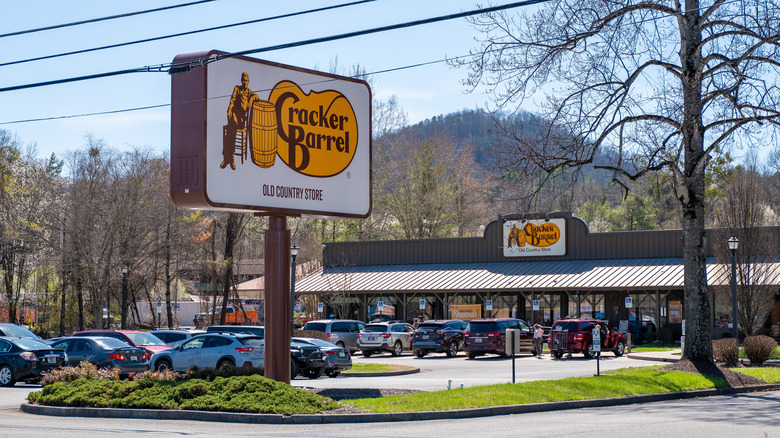 Cracker Barrel Old Country Store and sign and busy parking lot with cars and vehicles in Tennessee.