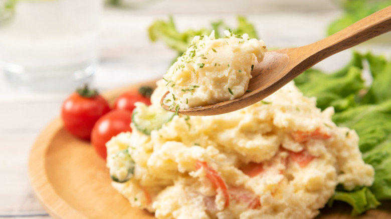 A wooden spoonful of potato salad
