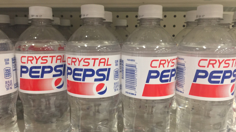A row of plastic bottles of Crystal Pepsi on a grocery shelf