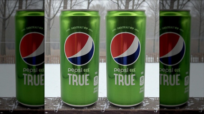 Two cans of Pepsi True against a window frame
