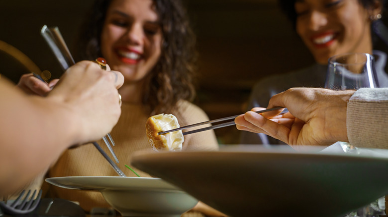 A group of smiling friends eating dim sum