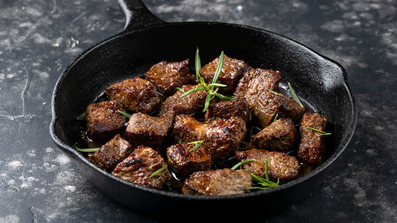 Garlic butter beef steak bites in iron cast pan