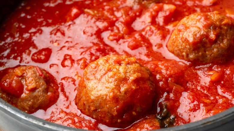 Close up of meatballs cooking in tomato sauce