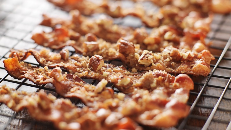 candied bacon with pecans and brown sugar cooling on baking rack