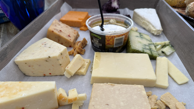 Trader Joe's unwrapped cheeses in wooden serving tray