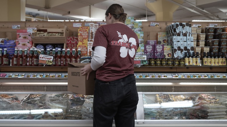A Trader Joe's employee stocks the shelves.
