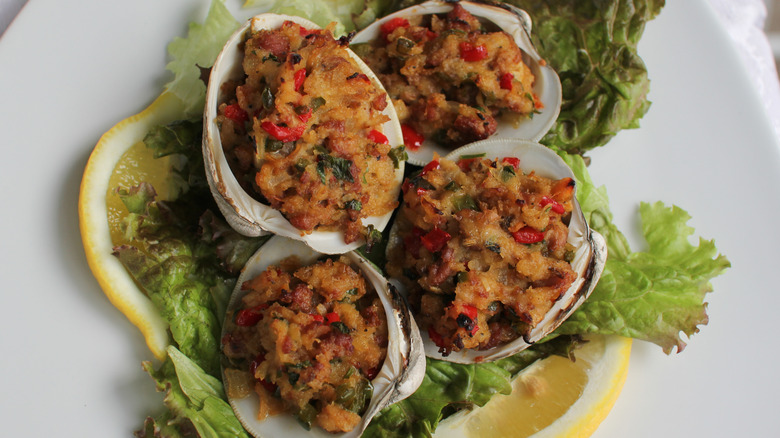 close up of several stuffed quahogs on a plate with lemon garnish