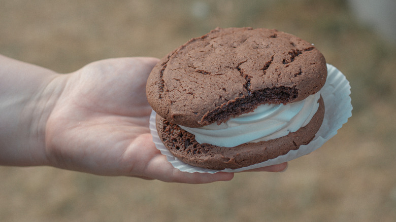 hand holding large chocolate whoopie pie on a plate