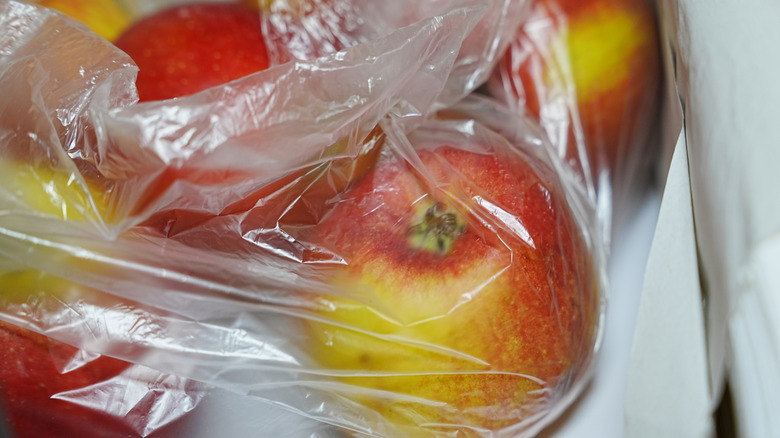 Fresh red apples are packaged in a transparent plastic bag