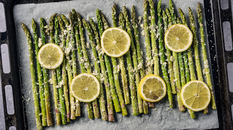 Asparagus on sheet tray with lemon slices and cheese