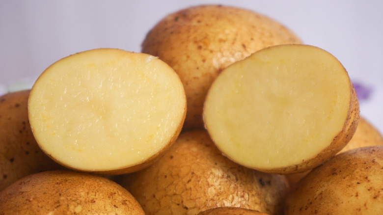 A pile of potatoes with one cut in half