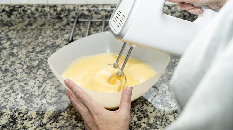 Person whipping cake batter in a small bowl