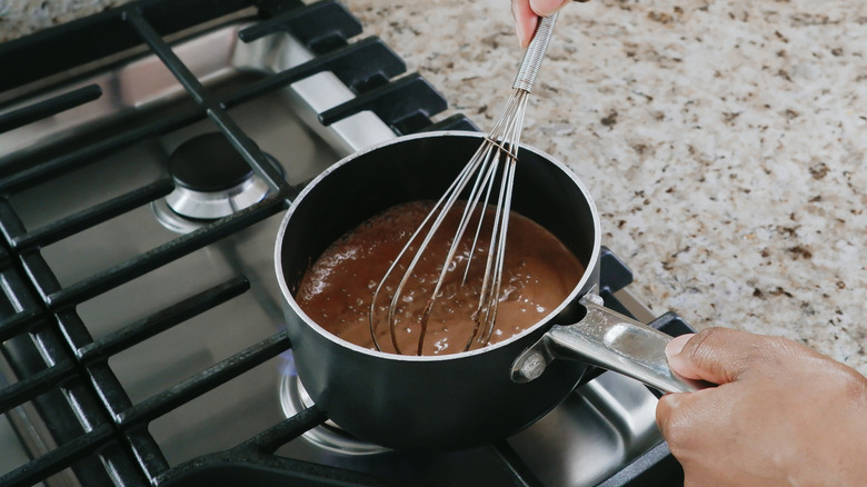 Person cooking chocolate batter on the stove
