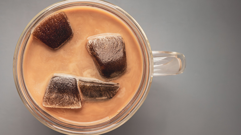 Coffee ice cubes with milk in cup