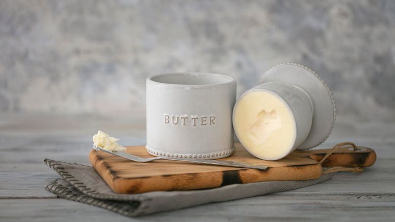 Vintage butter bell and silver knife on wood cutting board