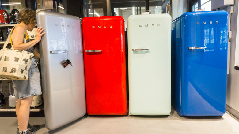 Shopper inspects Smeg brand refrigerators in a store