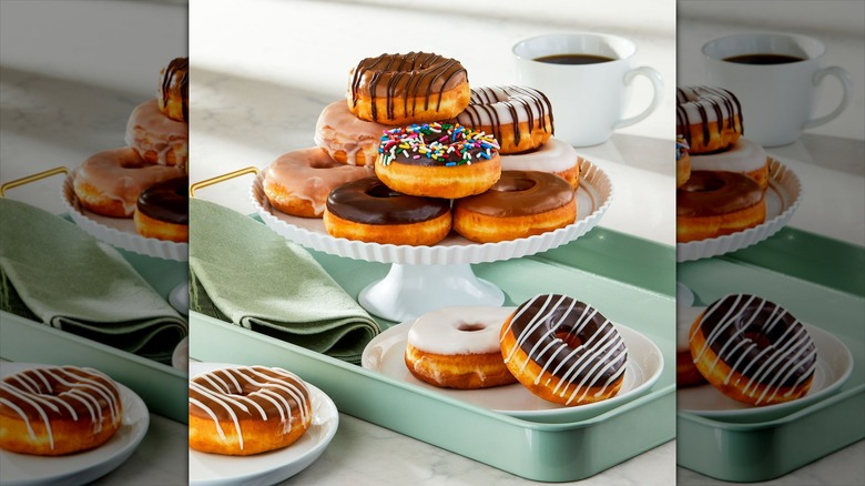 Walmart assorted ring donuts arranged on a cake stand with a cup of coffee in background