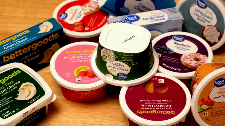 A pile of different Walmart cream cheese products on a wooden table