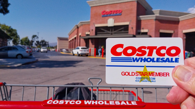 Close-up of shopper holding Costco membership card, outside the store