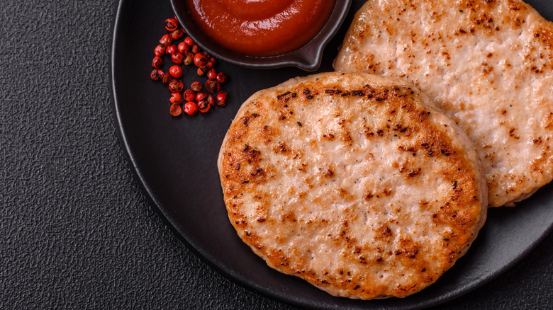 Cooked chicken patties with a bowl of tomato sauce