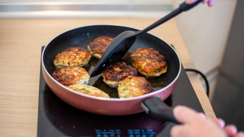 Chicken patties being cooked in a pan