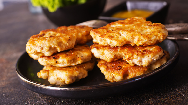 Fried chicken patties in a dark bowl