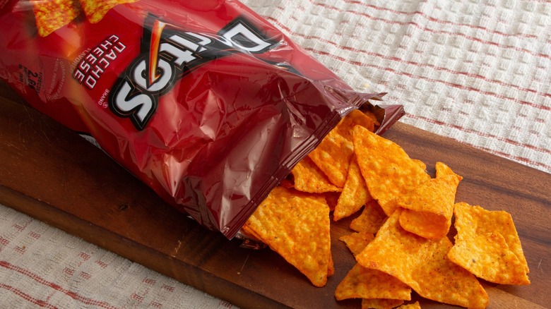 View of a package of Doritos Nacho Cheese, with the chips spilling out