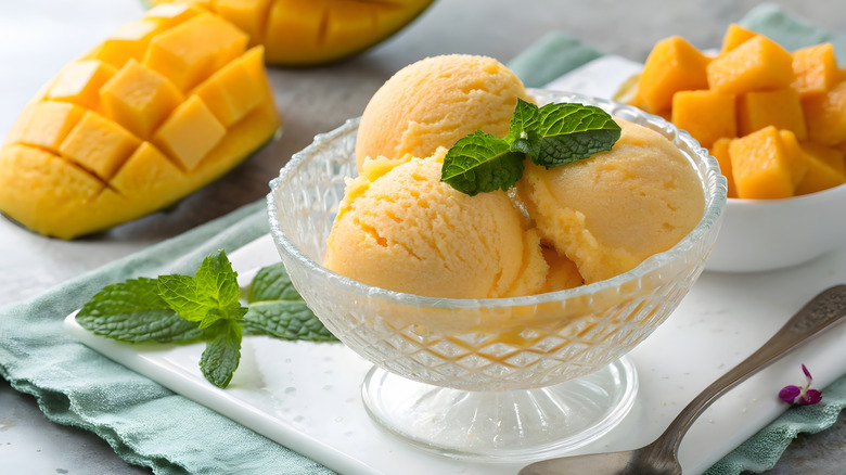 Mango sorbet in glass bowl with mint leaf