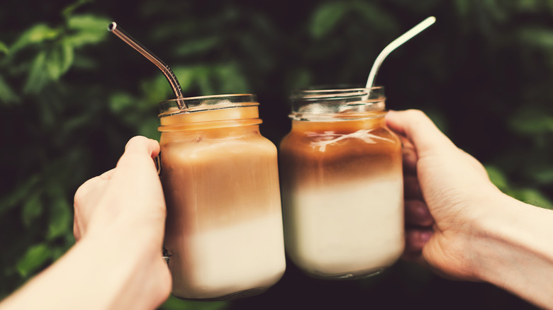 Hands holding up two iced coffees