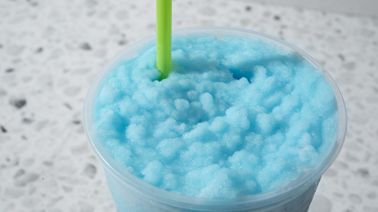 Blue slushy drink with green straw