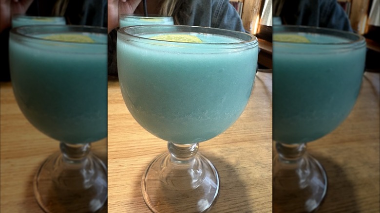 A slushy blue liquid in a goblet shaped glass