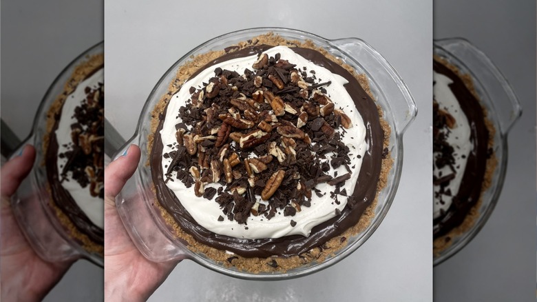 Hand holding tray of possum pie