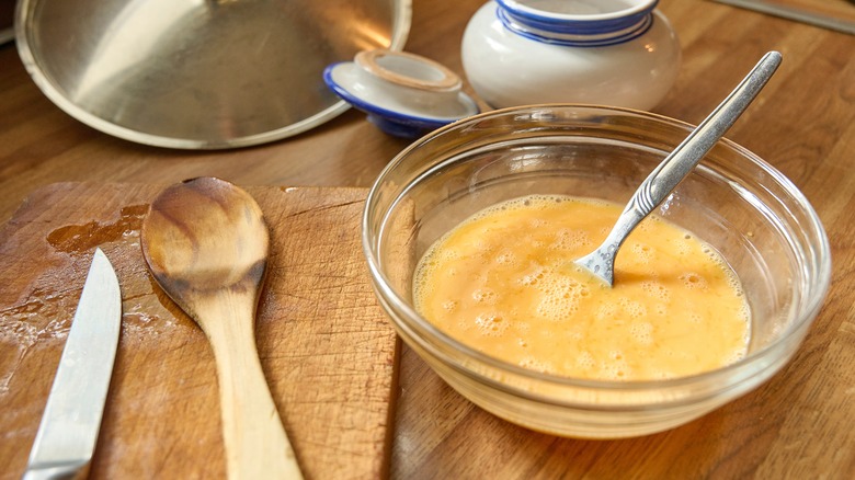Beaten egg in a glass bowl