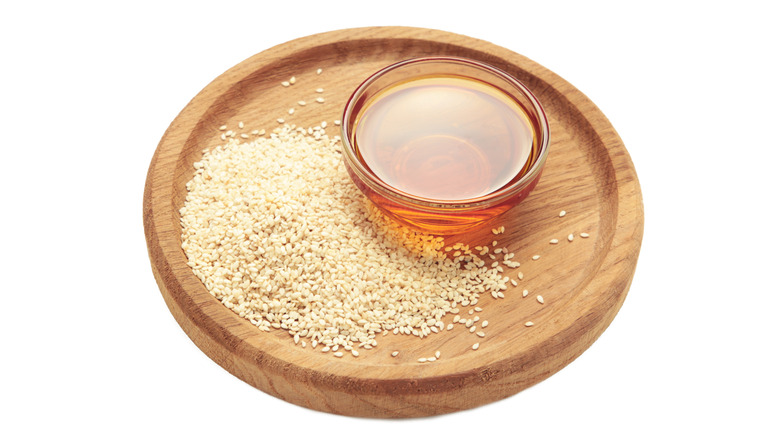 Sesame seeds and sesame oil isolated on white background.