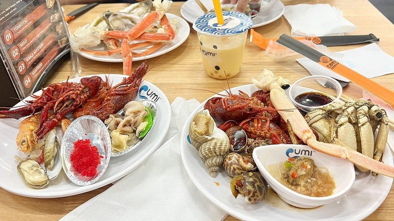 Plates of various seafood dishes at Umi Hotpot Sushi & Seafood Buffet