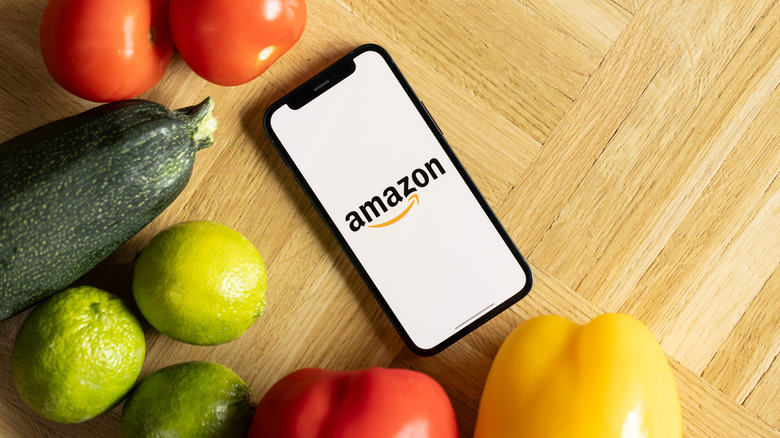 Phone with an Amazon logo surrounded by fresh vegetables