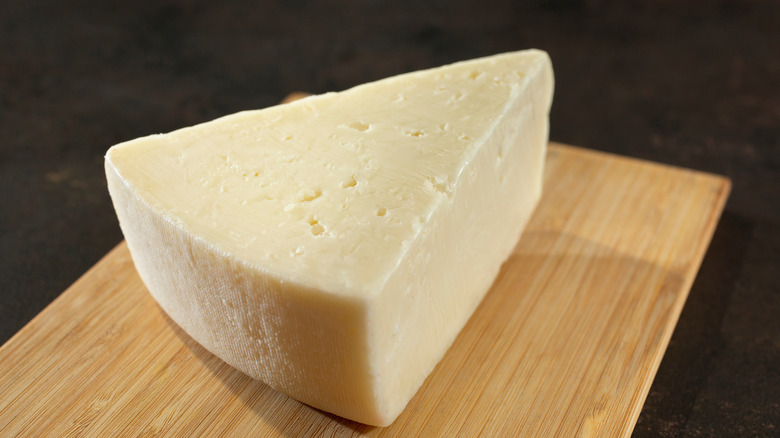 Piece of fontina cheese on a wood board