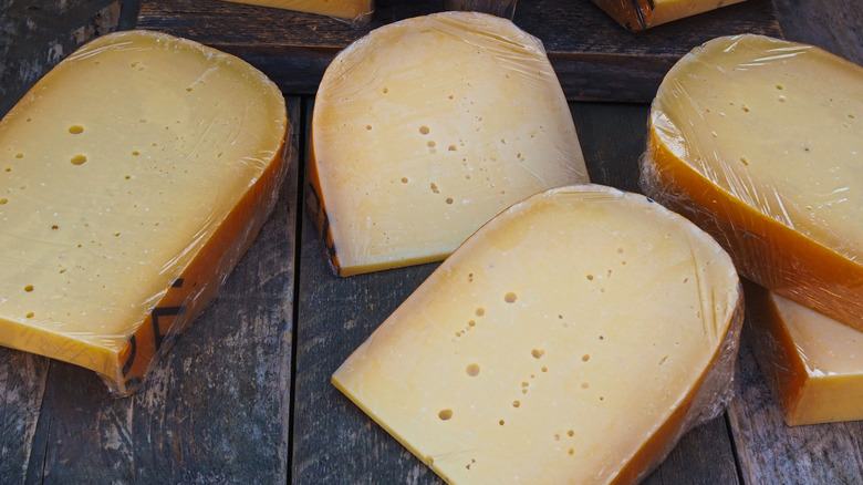 Slices of gouda cheese on a wood table
