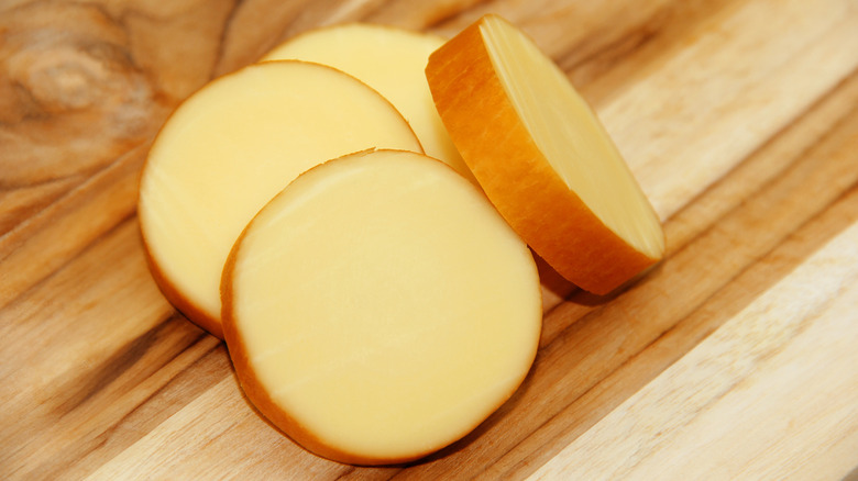 Provolone cheese slices on a wood board