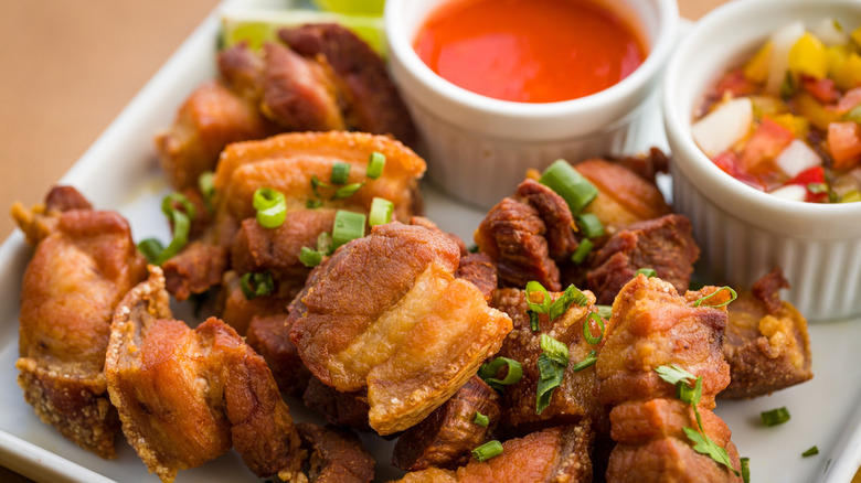 Crispy Pork Belly Chicharrón with Dipping Sauces on a white Plate