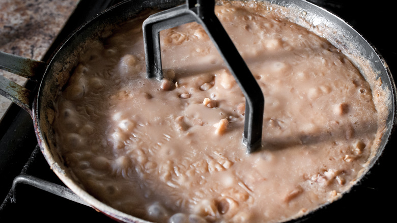 Mexican Frijoles Refritos or fried beans in a cooking pan,