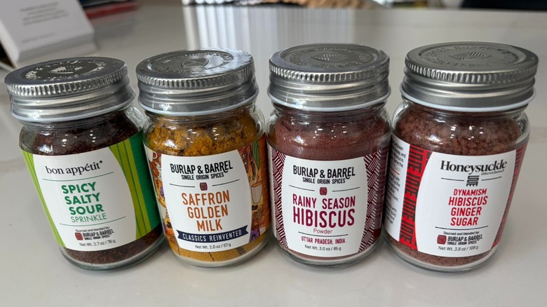 Four jars of Burlap & Barrel seasonings and spices on tabletop