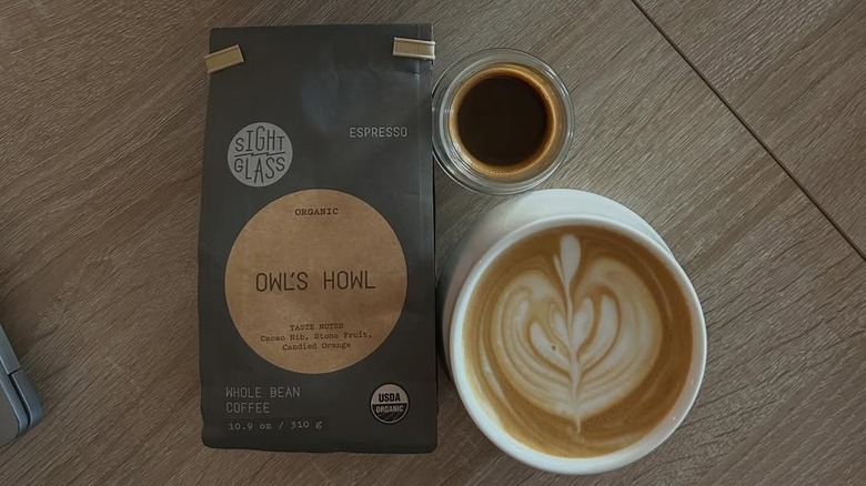 Top view of a bag of Owl's Howl coffee beans from Trade Coffee, a shot of espresso, and a latte