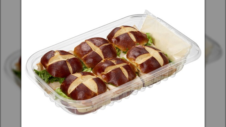 A container of the Kirkland Signature Chicken Sandwich on Pretzel Buns from Costco with a packet of sauce within it