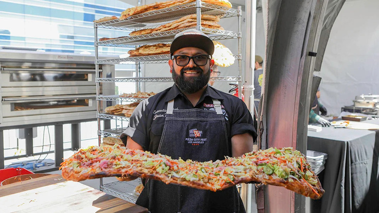 A man serving pizza at the Pizza City Fest Los Angeles